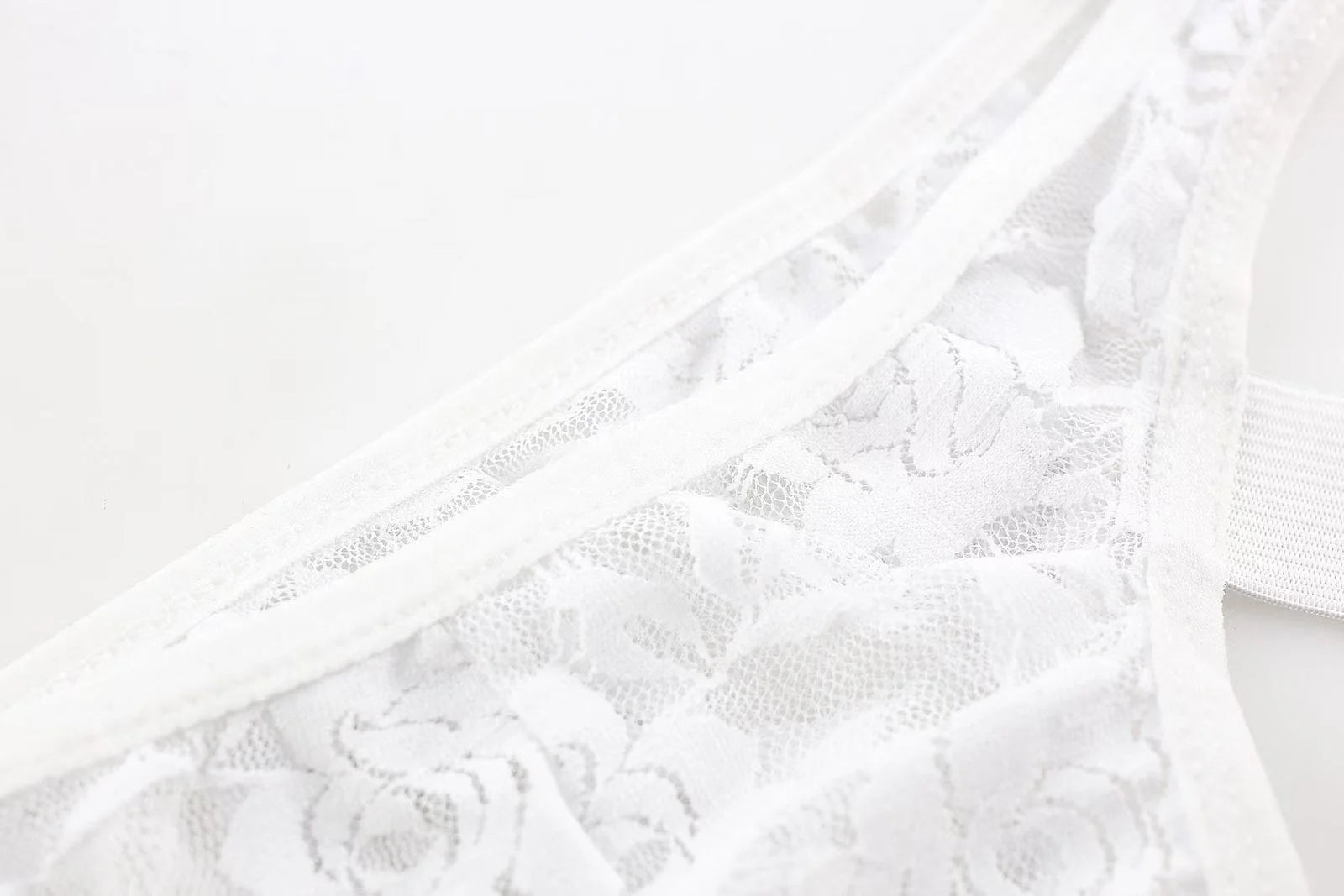 Close-up of white lace fabric texture on men’s sheer thong underwear
