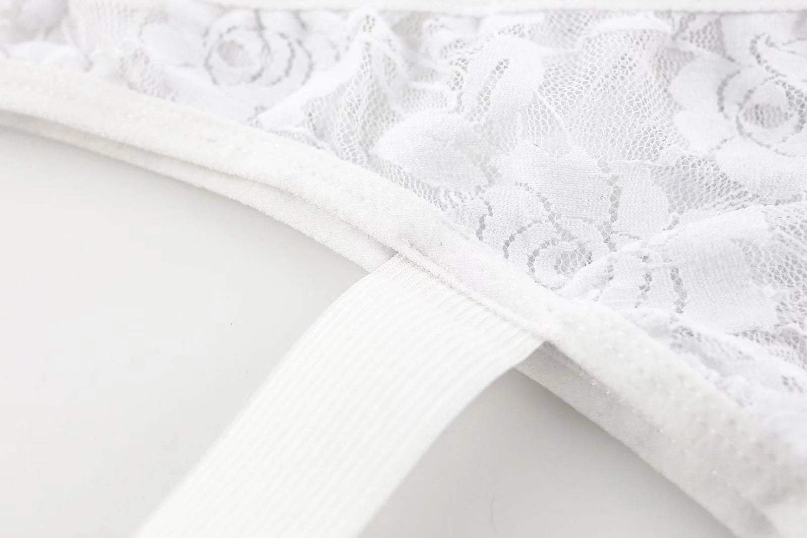 Detailed view of white double strap design on men’s sexy lace thong