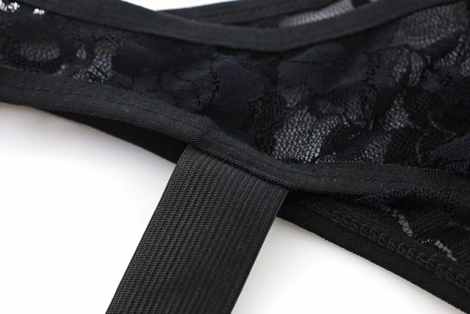 Close-up of black lace fabric texture on men’s sheer thong underwear